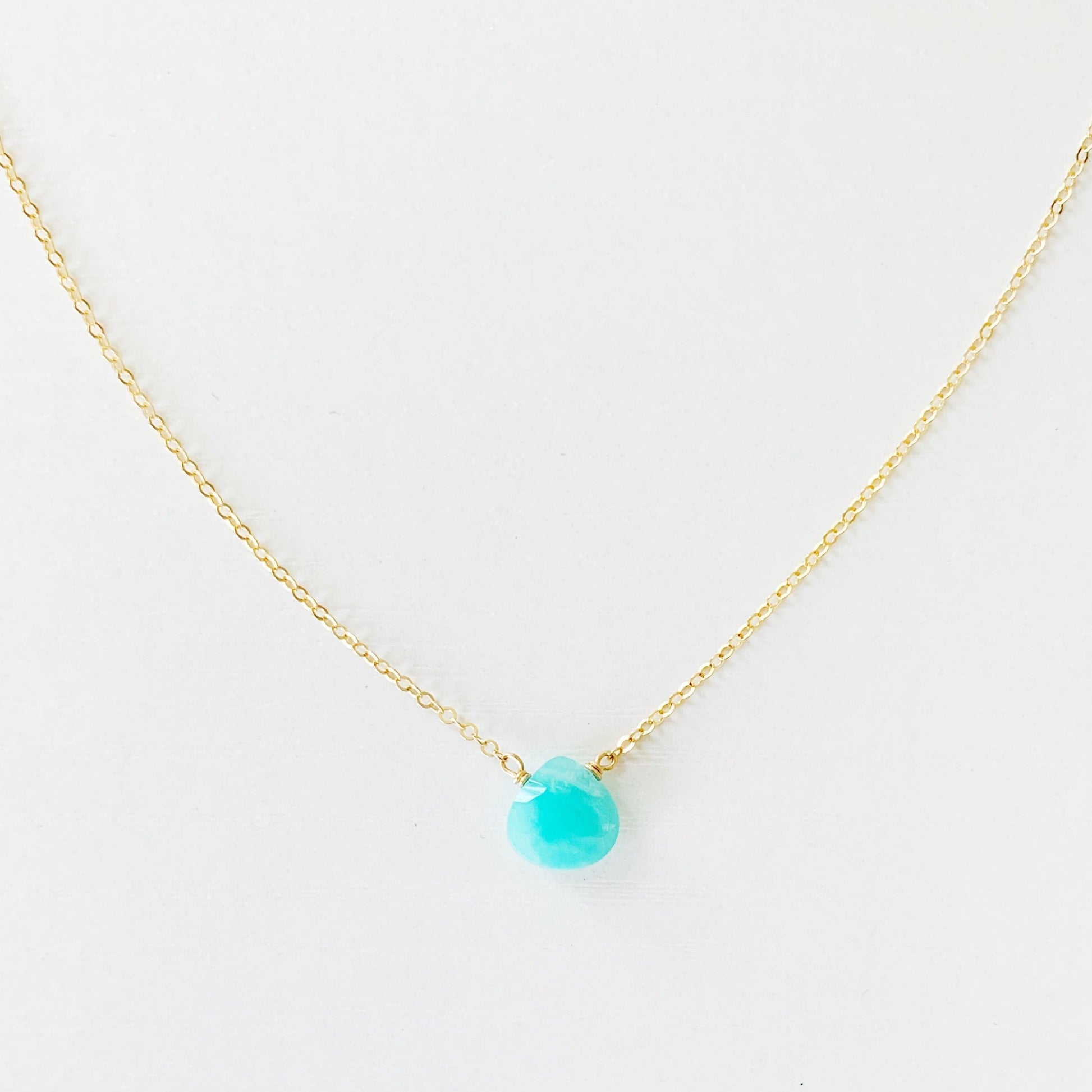 the captiva necklace by mermaids and madeleines is a small amazonite briolette hanging on 14k gold filled chain. this necklace is photographed on a white surface