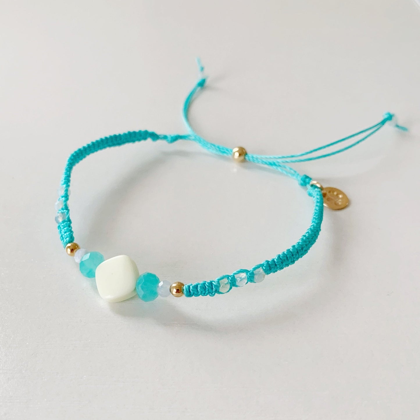 The captiva macrame bracelet in color blue crush pictured on top of a white surface