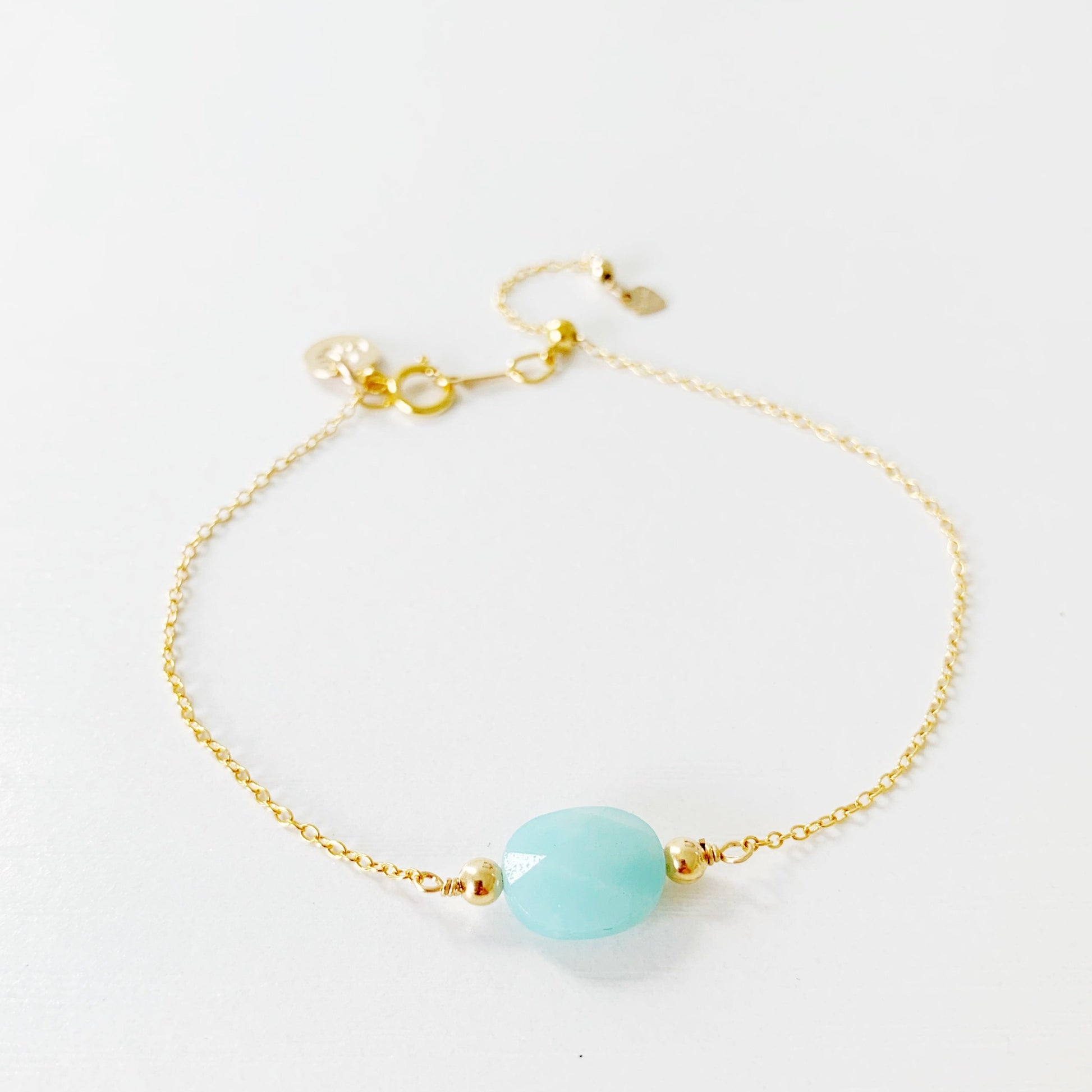 the mermaids and madeleines laguna bracelet is a 14k gold filled chain bracelet with a faceted amazonite oval at the center and a slide bead near the clasp so the bracelet adjusts. this bracelet is photographed on a white surface