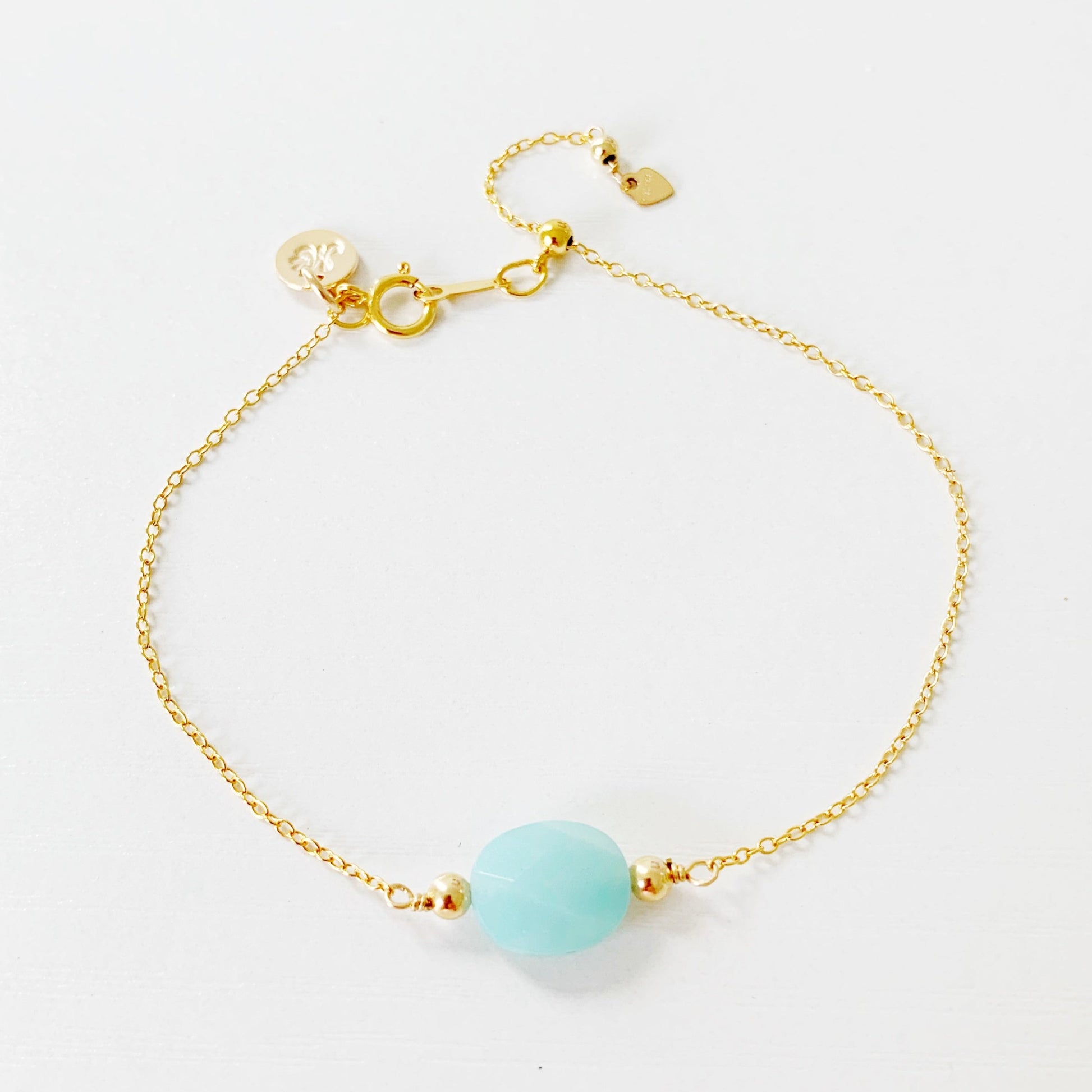 the mermaids and madeleines laguna bracelet is a 14k gold filled chain bracelet with a faceted amazonite oval at the center and a slide bead near the clasp so the bracelet adjusts. this bracelet is photographed on a white surface