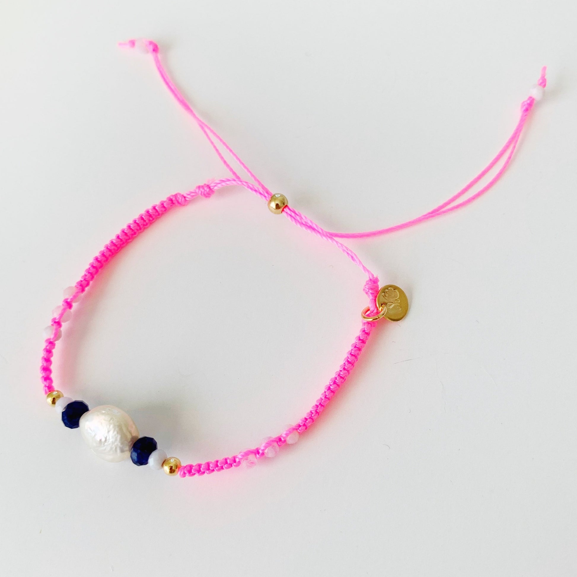 A top down view of the bristol bracelet in hot pink. This bracelet is photographed on a white surface